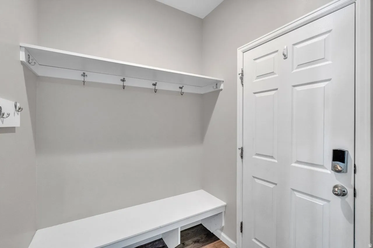 Entryway featuring built-in bench seating, upper shelf storage, and multiple coat hooks