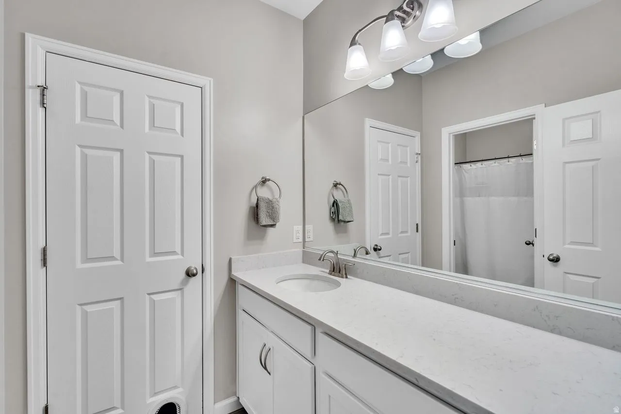 Bathroom vanity featuring an integrated sink, brushed nickel faucet, and a light-toned countertop