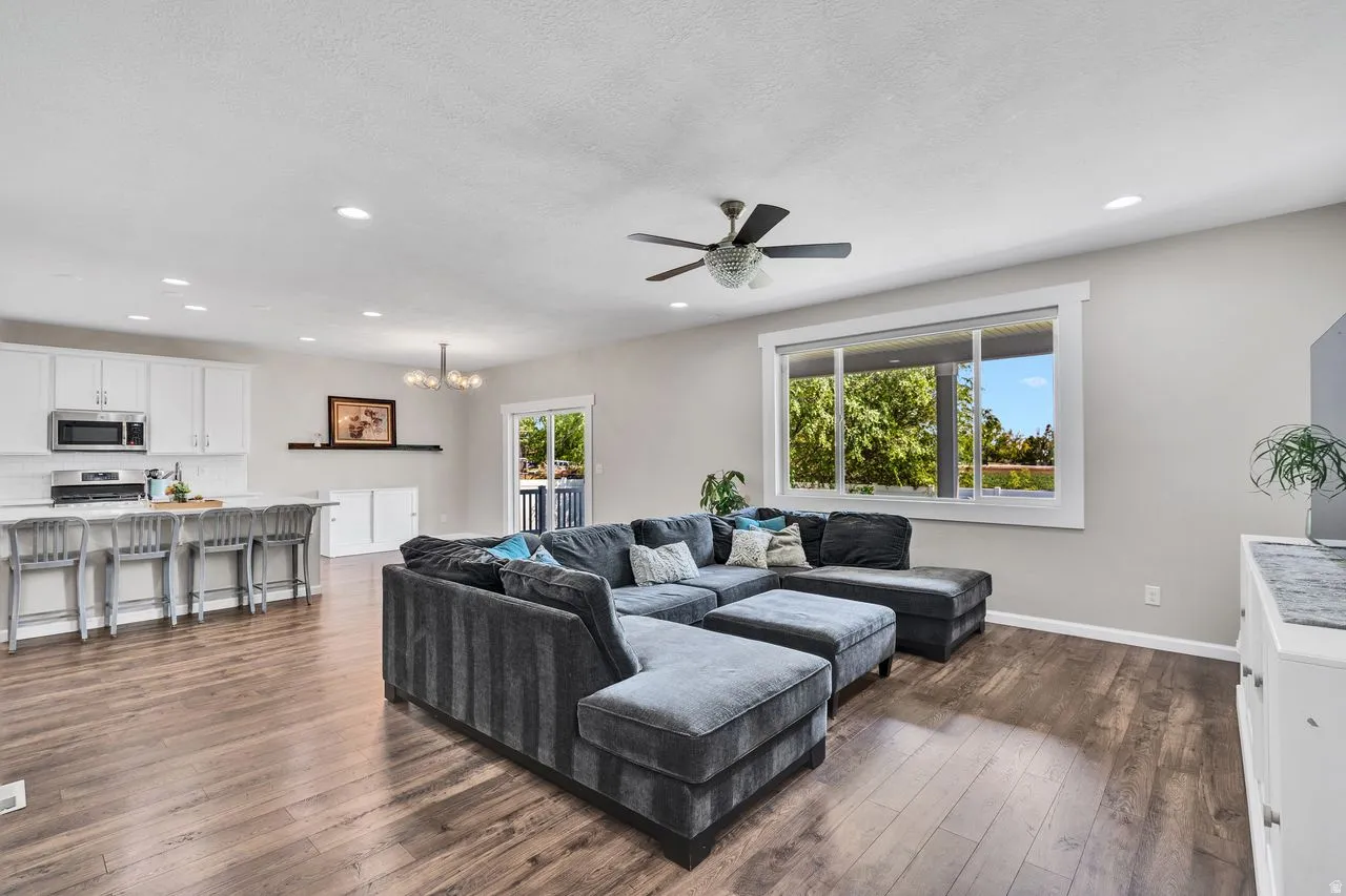 Open-concept living area featuring wood-finish flooring, recessed lighting, and a ceiling fan