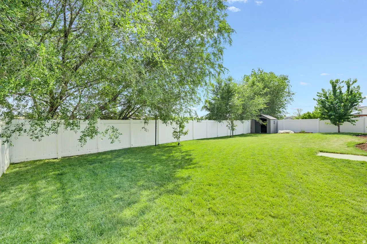 Expansive green lawn encompassed by a white privacy fence