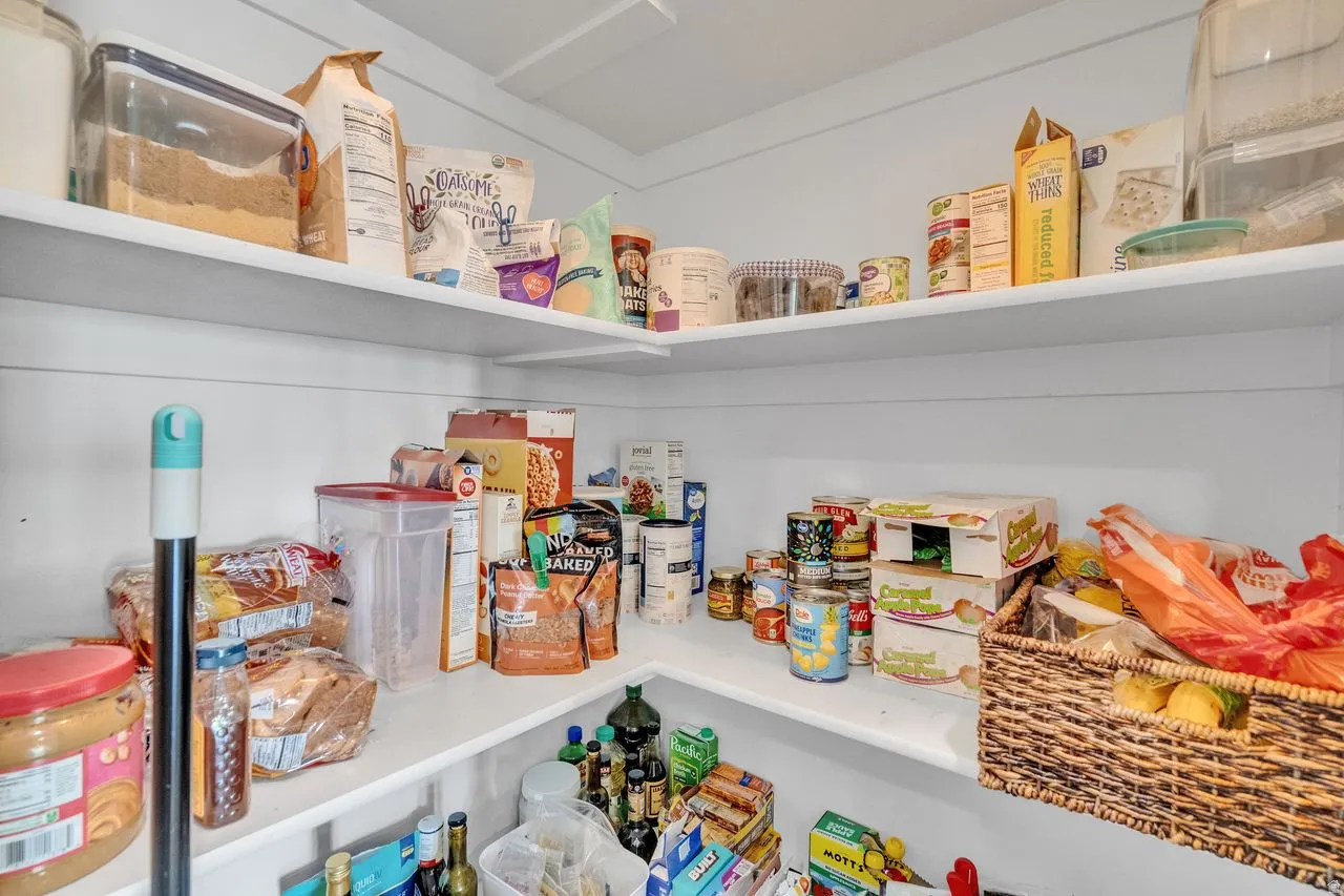 Built-in pantry shelving featuring white finishes and a corner configuration