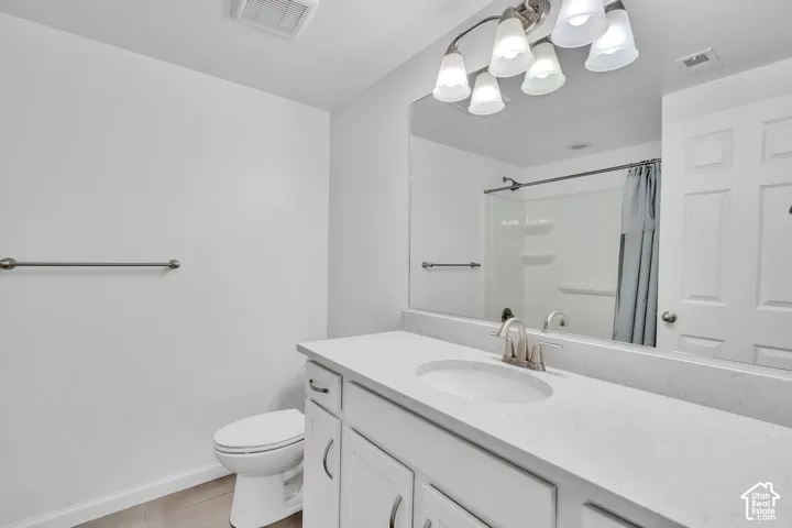 Bathroom vanity featuring a single basin, brushed nickel faucet, and a light-toned countertop