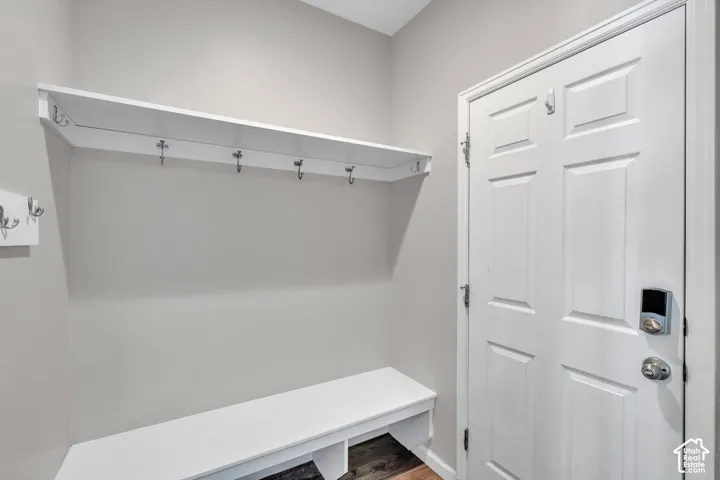 Entryway featuring built-in bench seating, upper shelf storage, and multiple coat hooks
