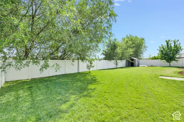 Expansive green lawn encompassed by a white privacy fence