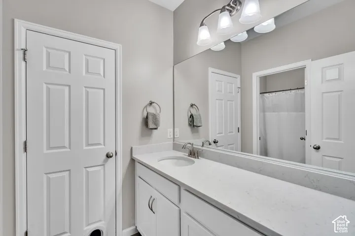 Bathroom vanity featuring an integrated sink, brushed nickel faucet, and a light-toned countertop