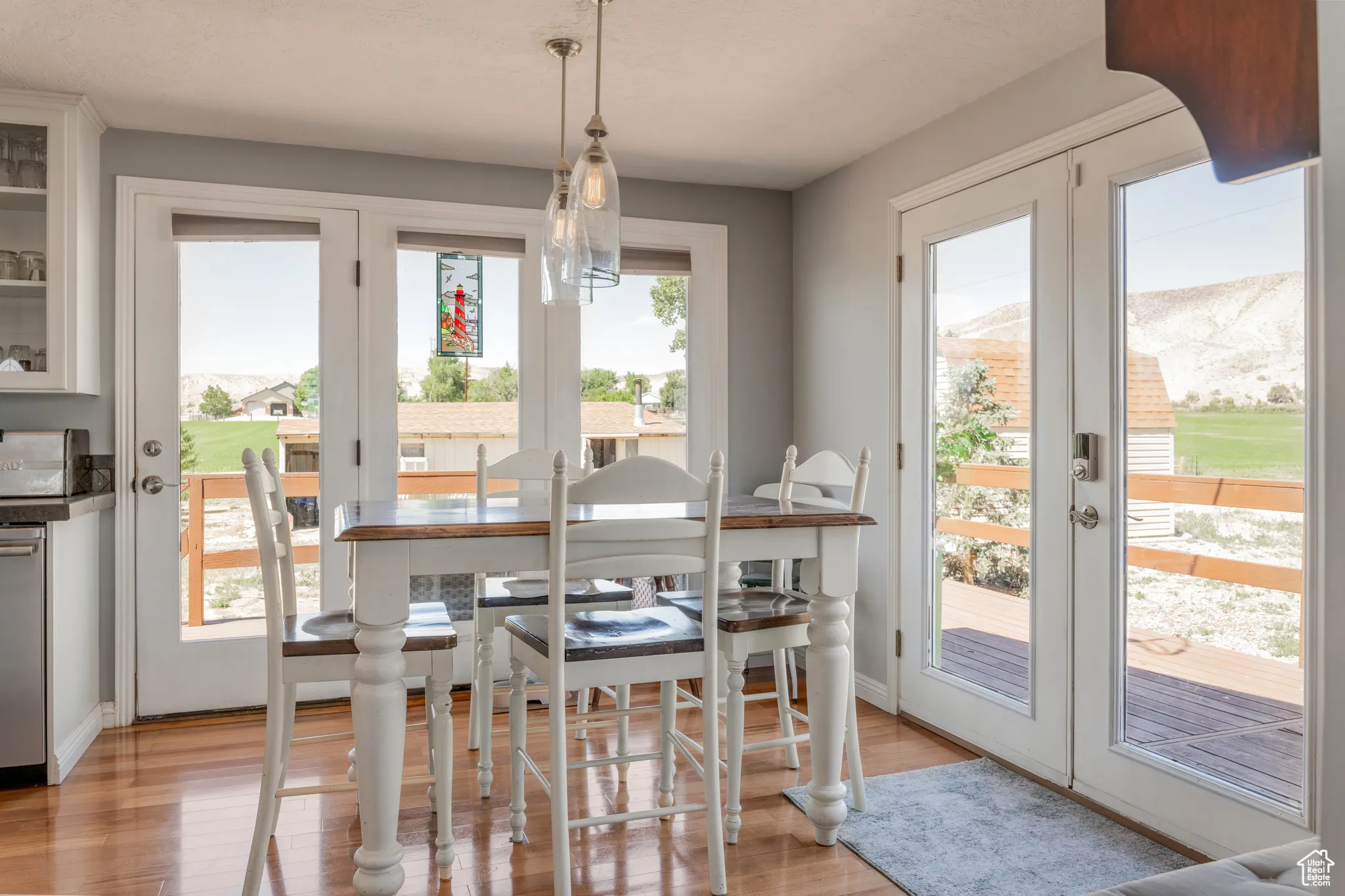 Hardwood flooring extends through the dining area, featuring a contemporary pendant light fixture