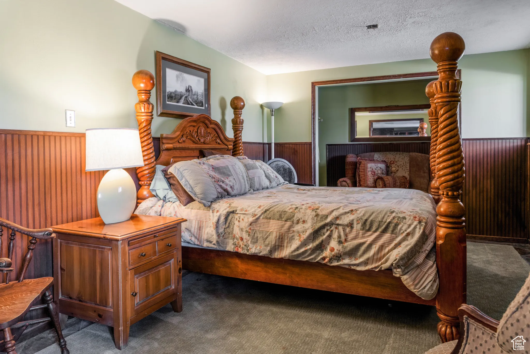 Bedroom featuring light green walls, wood-finish wainscoting, and carpet flooring