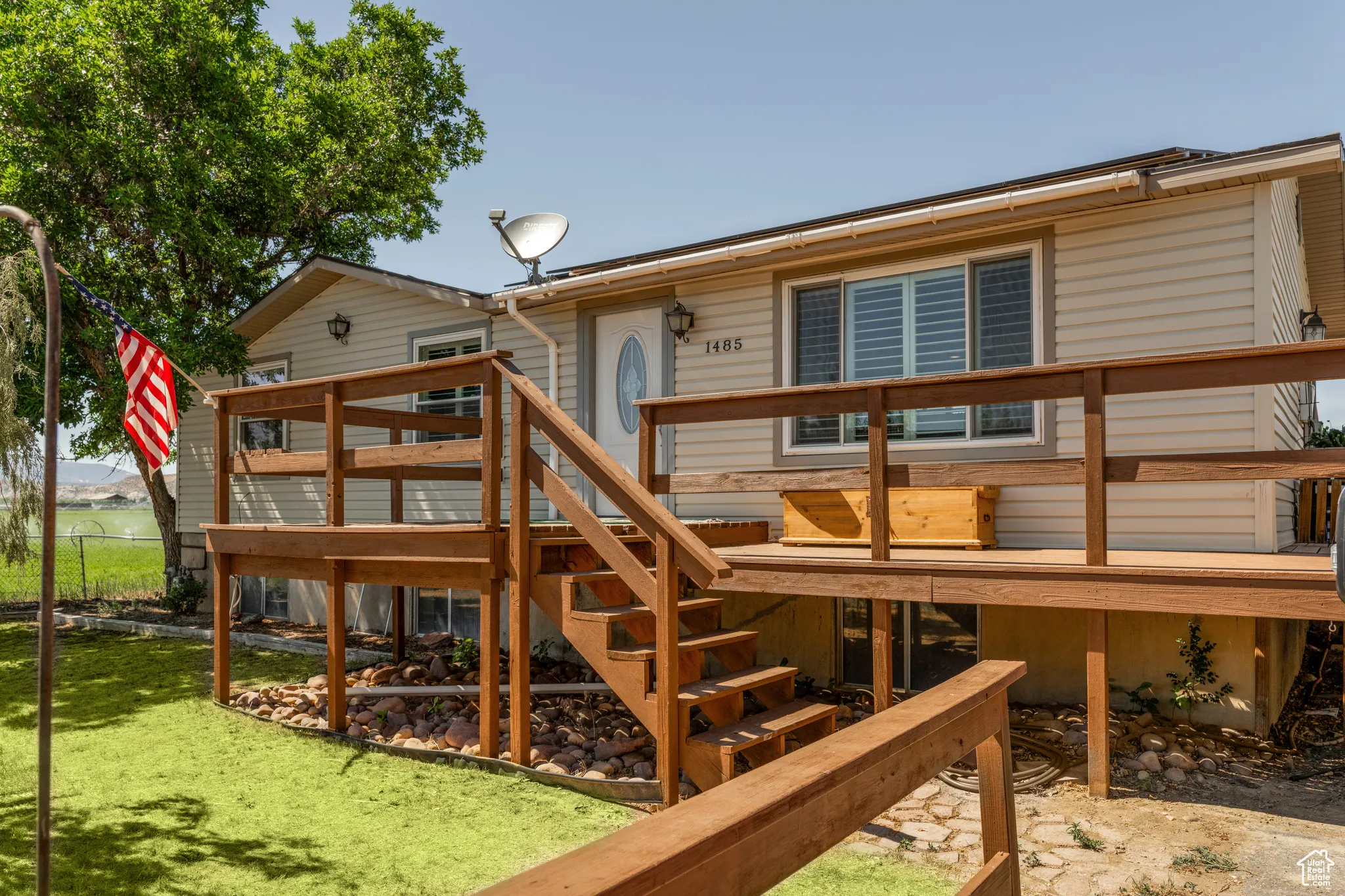 Raised wooden deck with stairs and railing provides exterior access