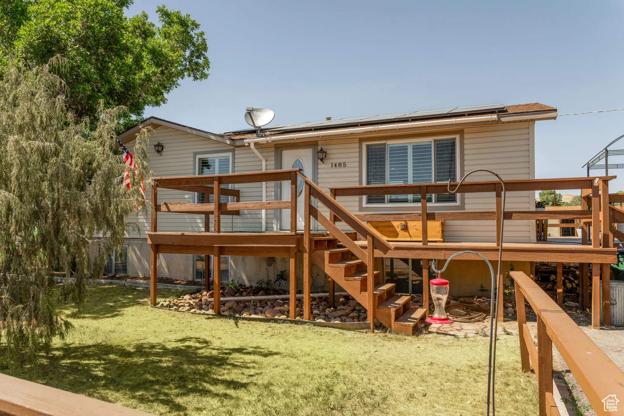 Siding exterior with a large wood-finish deck and stairs