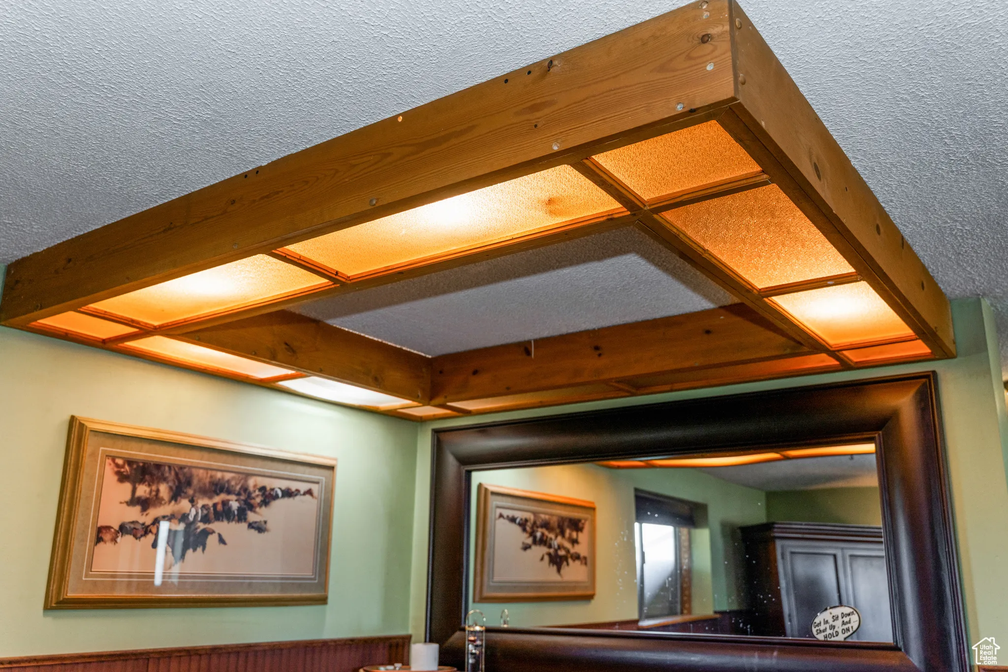 Wood-framed ceiling light fixture featuring frosted panels and a textured ceiling