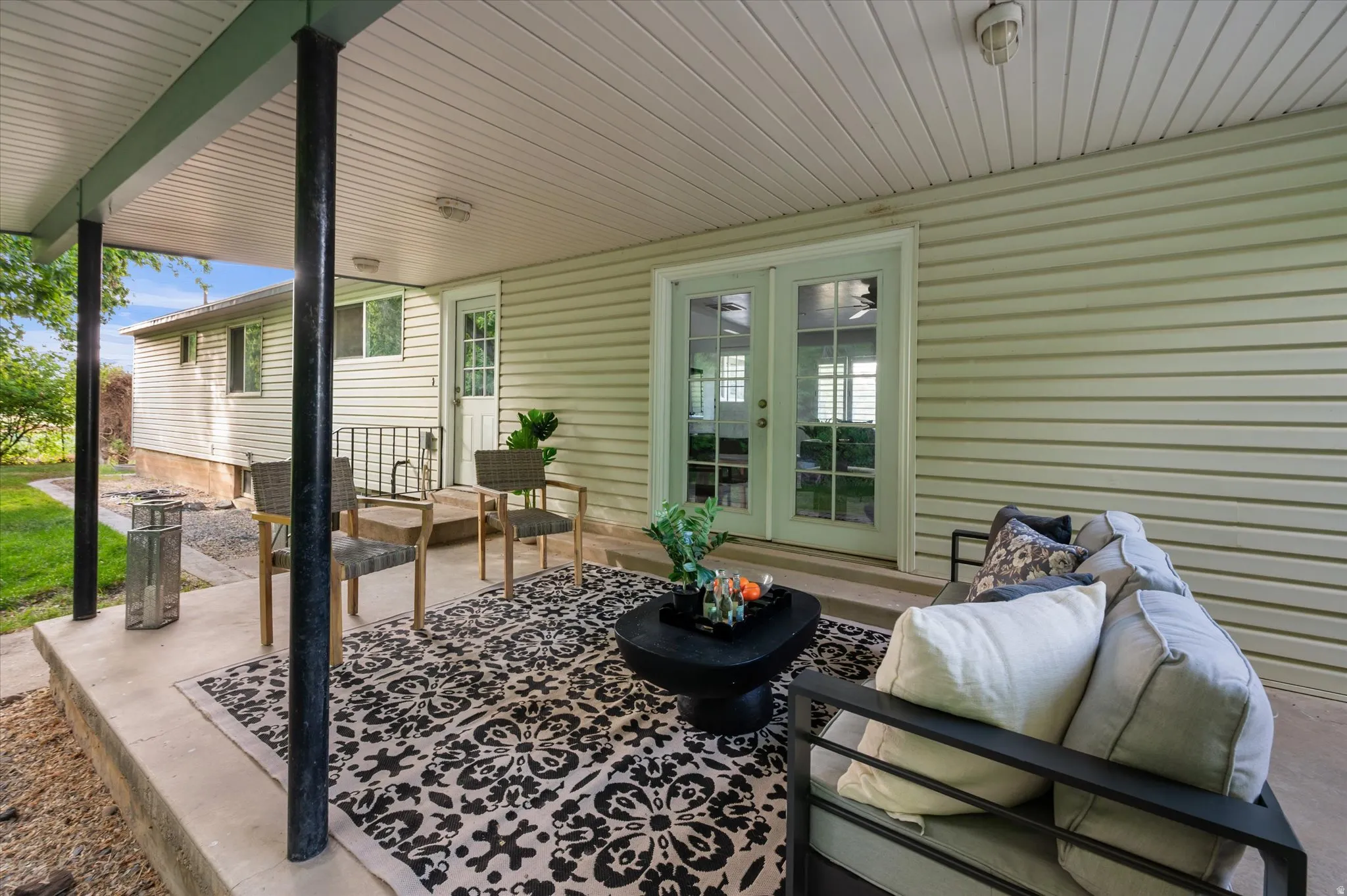Covered patio featuring concrete flooring and black support columns