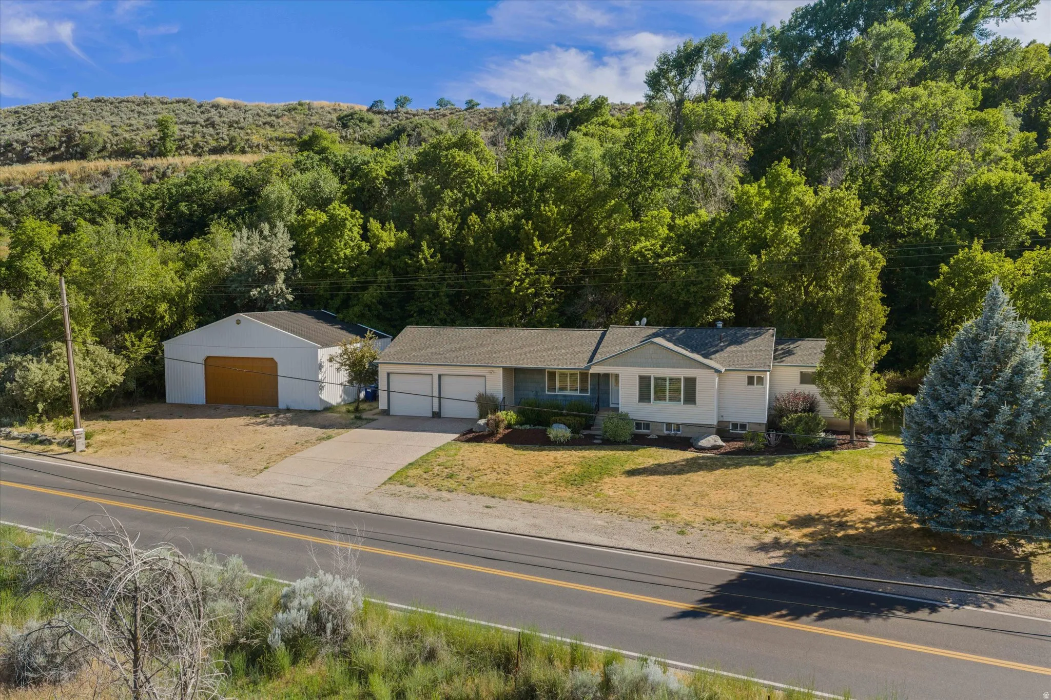 Ranch-style residence featuring a two-car garage and an additional detached garage with a single bay door