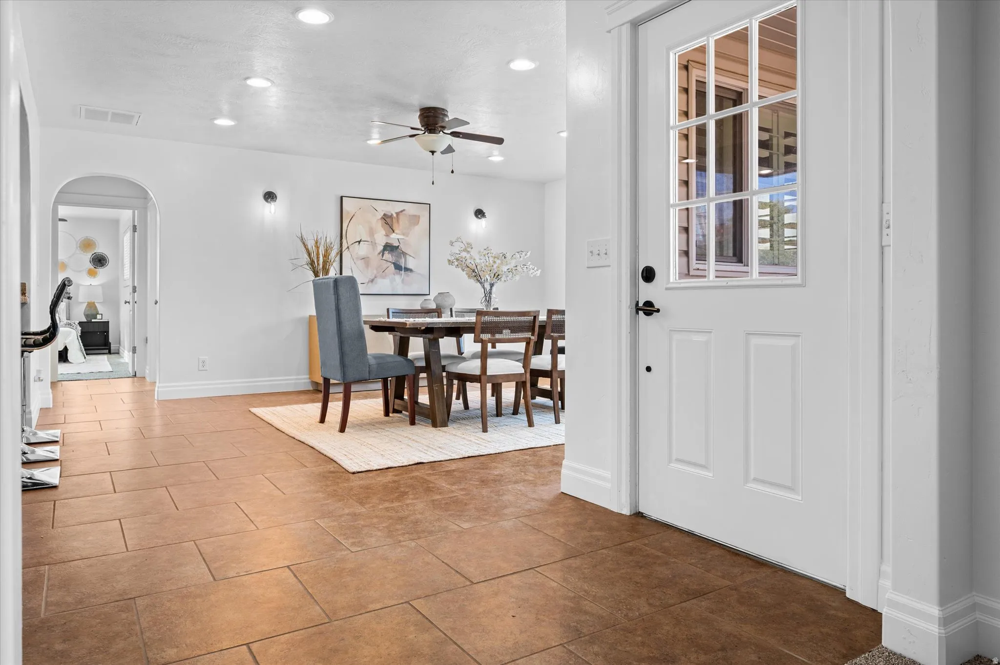 Entryway featuring rectangular floor tiles and a paneled door with divided lite glass