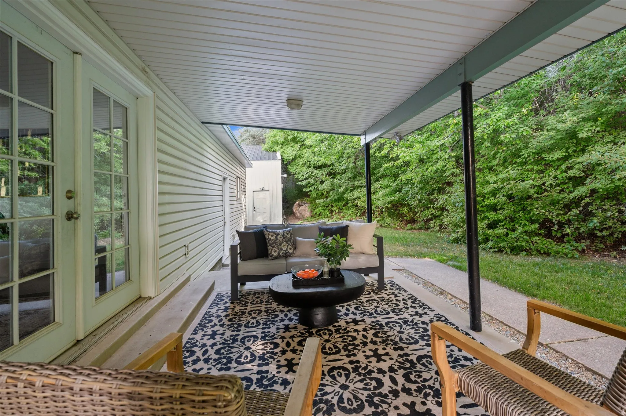 Covered patio featuring a slatted ceiling, recessed lighting, and support columns