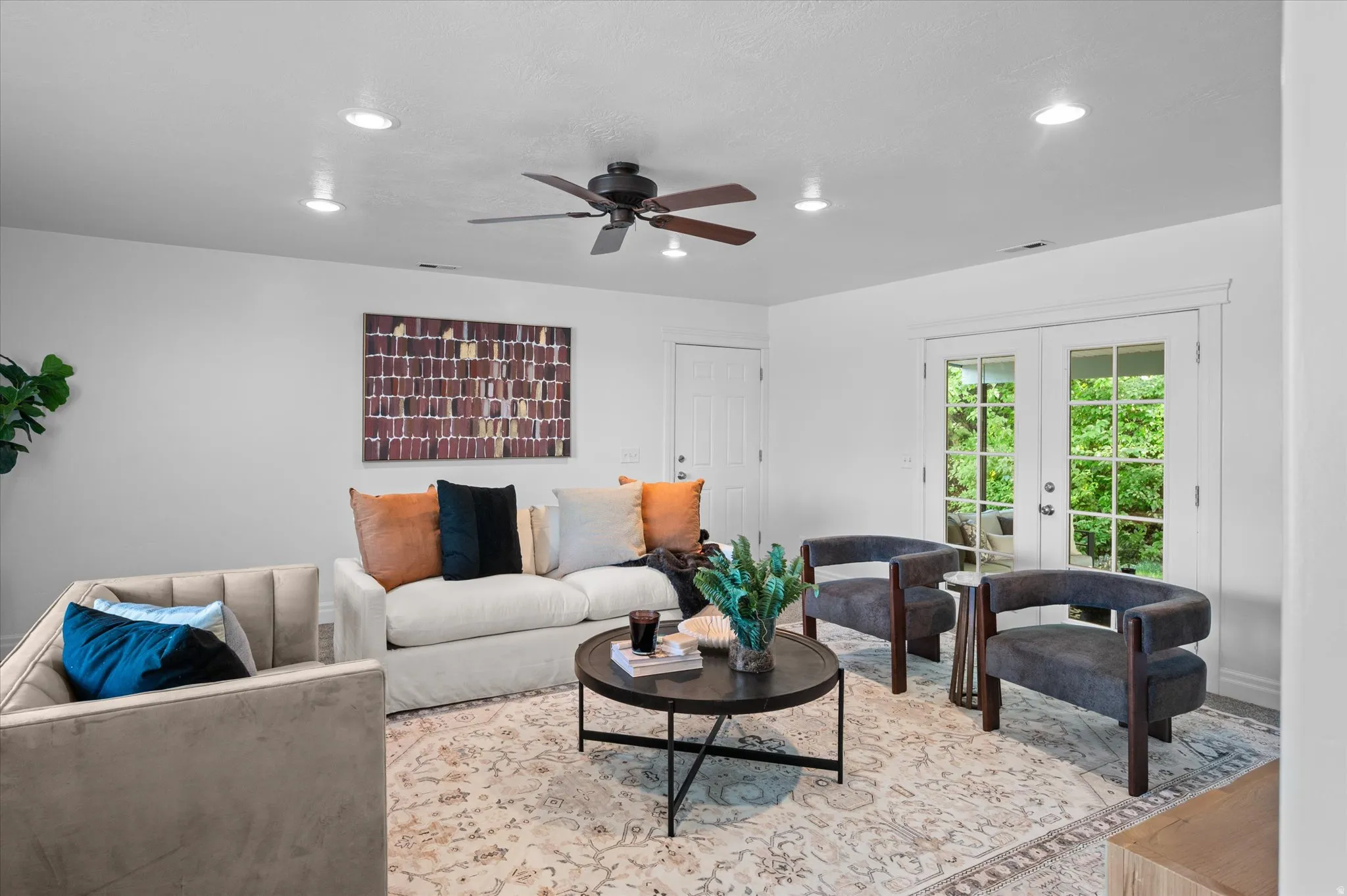 Bright living area featuring recessed lighting, a ceiling fan, and French doors leading to exterior space