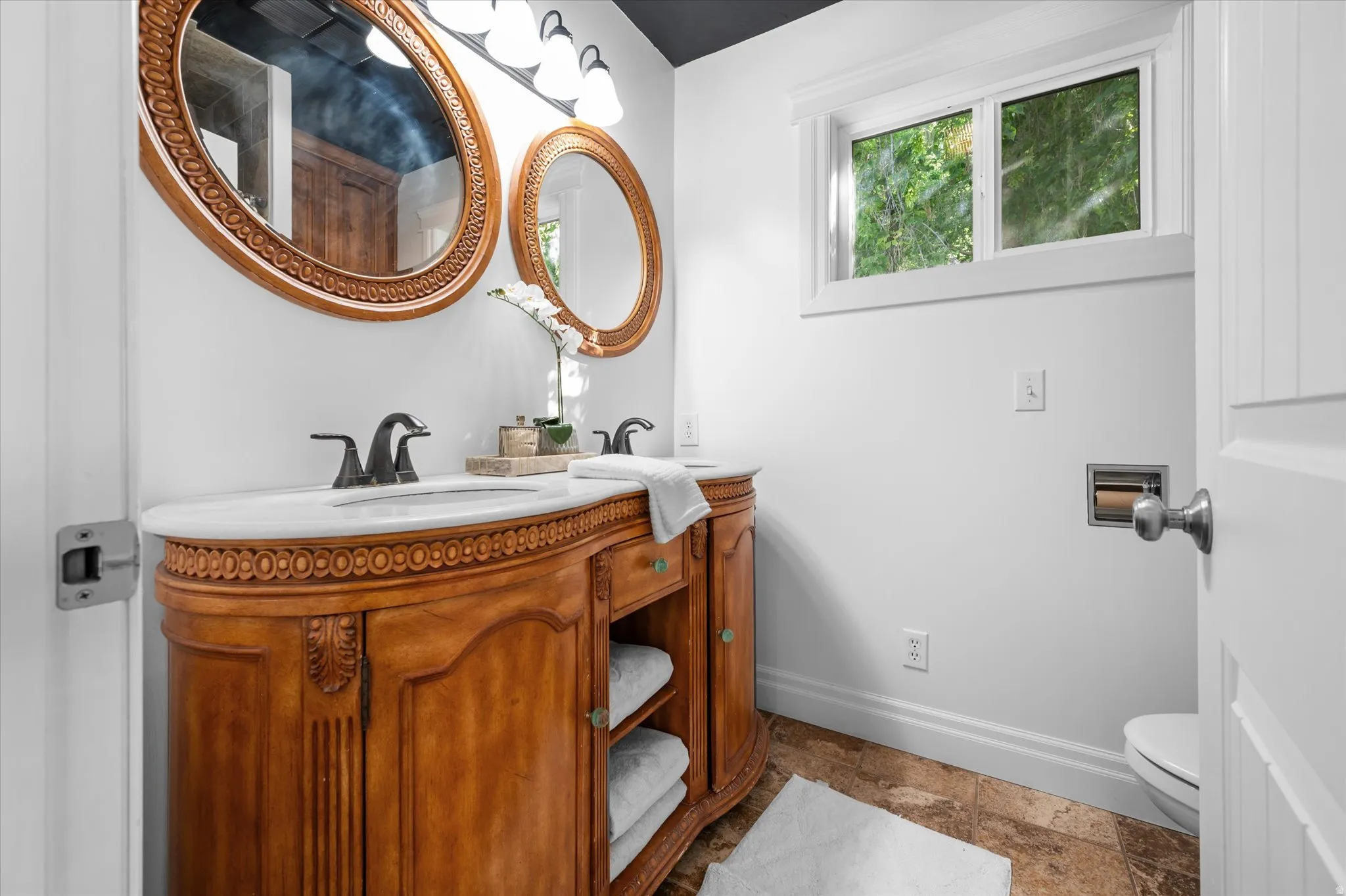 Dual vanity featuring a white countertop and ornate wood-finish cabinetry