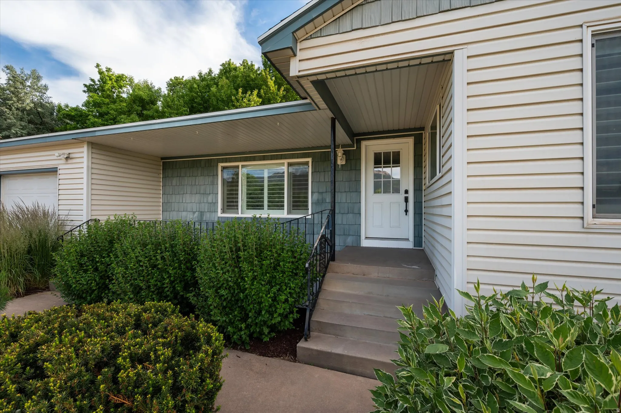 Entryway featuring a white paneled door with windowpanes, dark hardware, and a covered porch