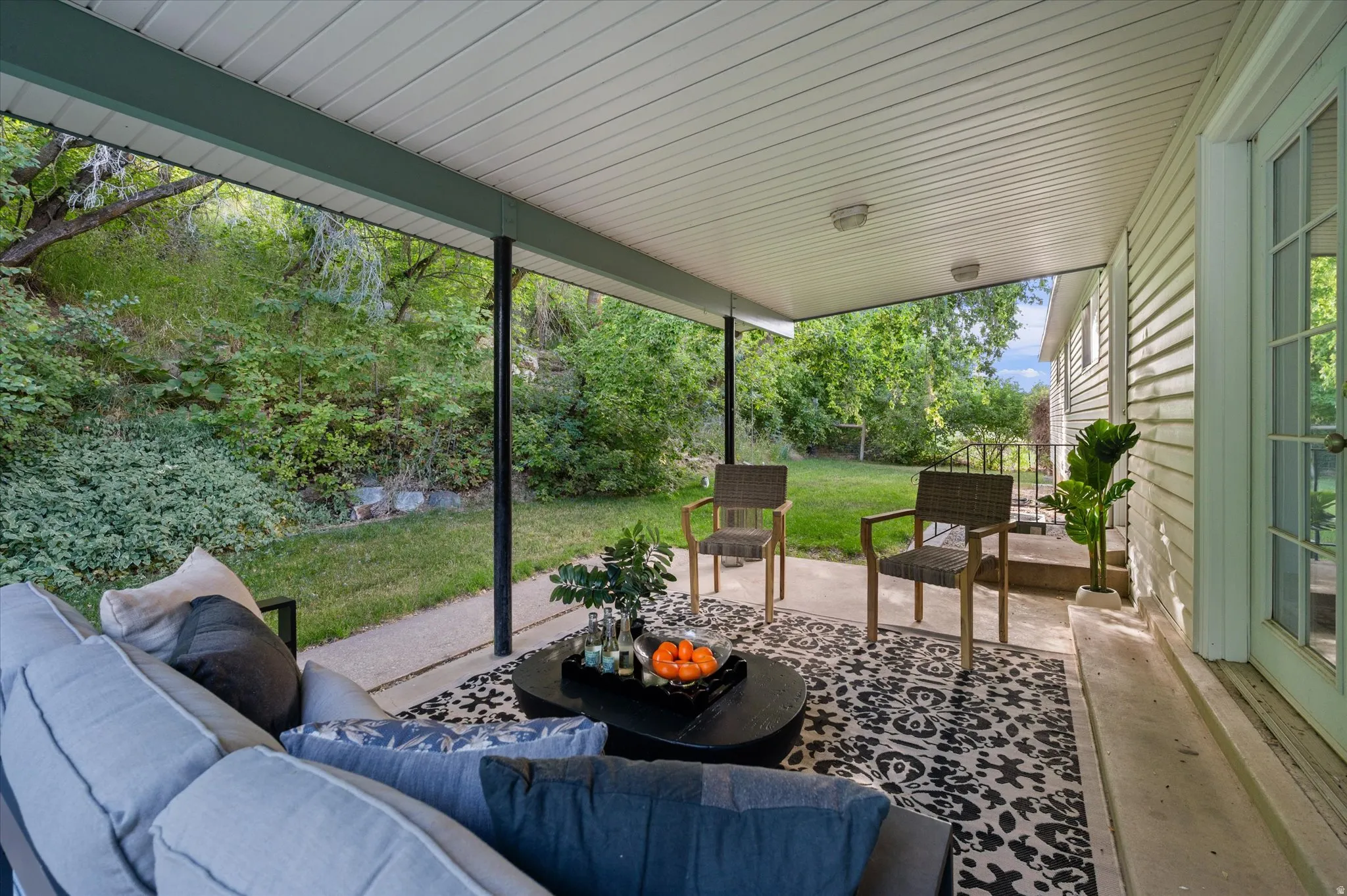 Covered patio space featuring a beadboard ceiling with recessed lighting, an outdoor area rug, and a concrete patio surface