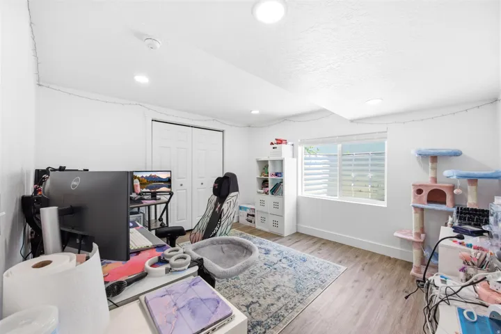 Bright room featuring wood-finish flooring, a double window, and recessed lighting