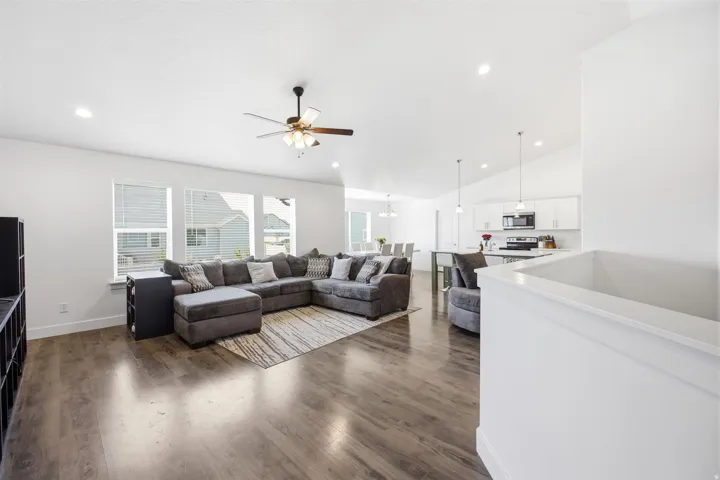 Open-concept living space featuring wood-finish flooring, recessed lighting, and a ceiling fan
