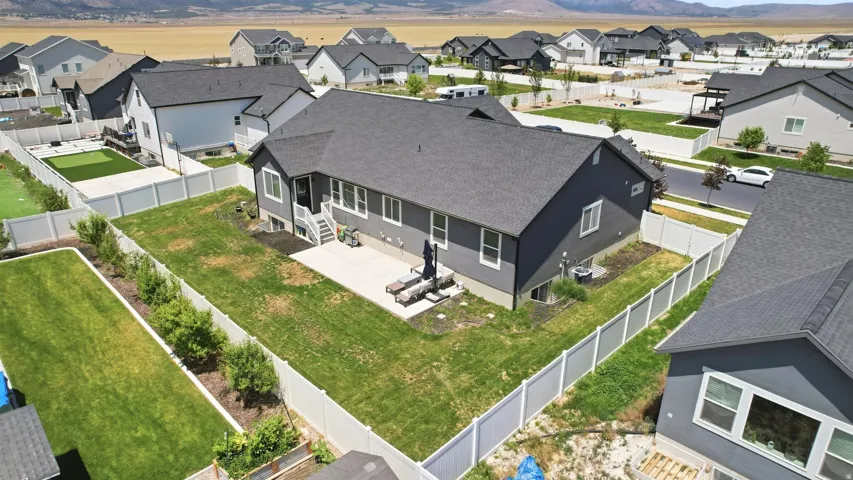 Private backyard featuring a concrete patio, perimeter fencing, and mature landscaping
