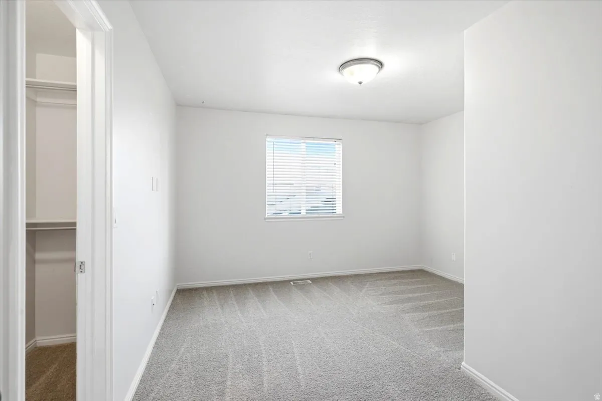 Neutral tone wall paint with a window featuring horizontal blinds