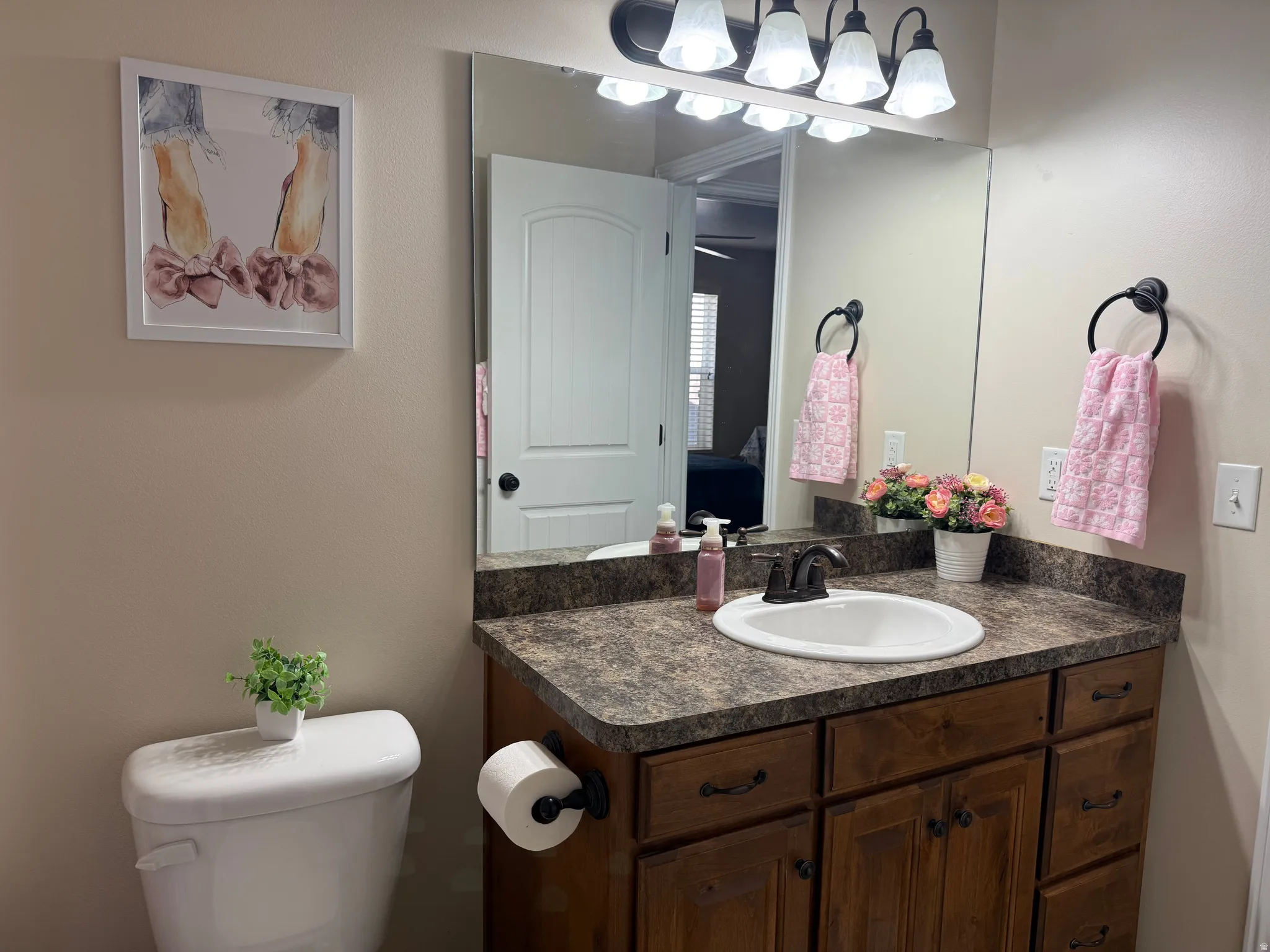 Vanity with a laminate countertop, integrated sink, and wood-finish cabinetry