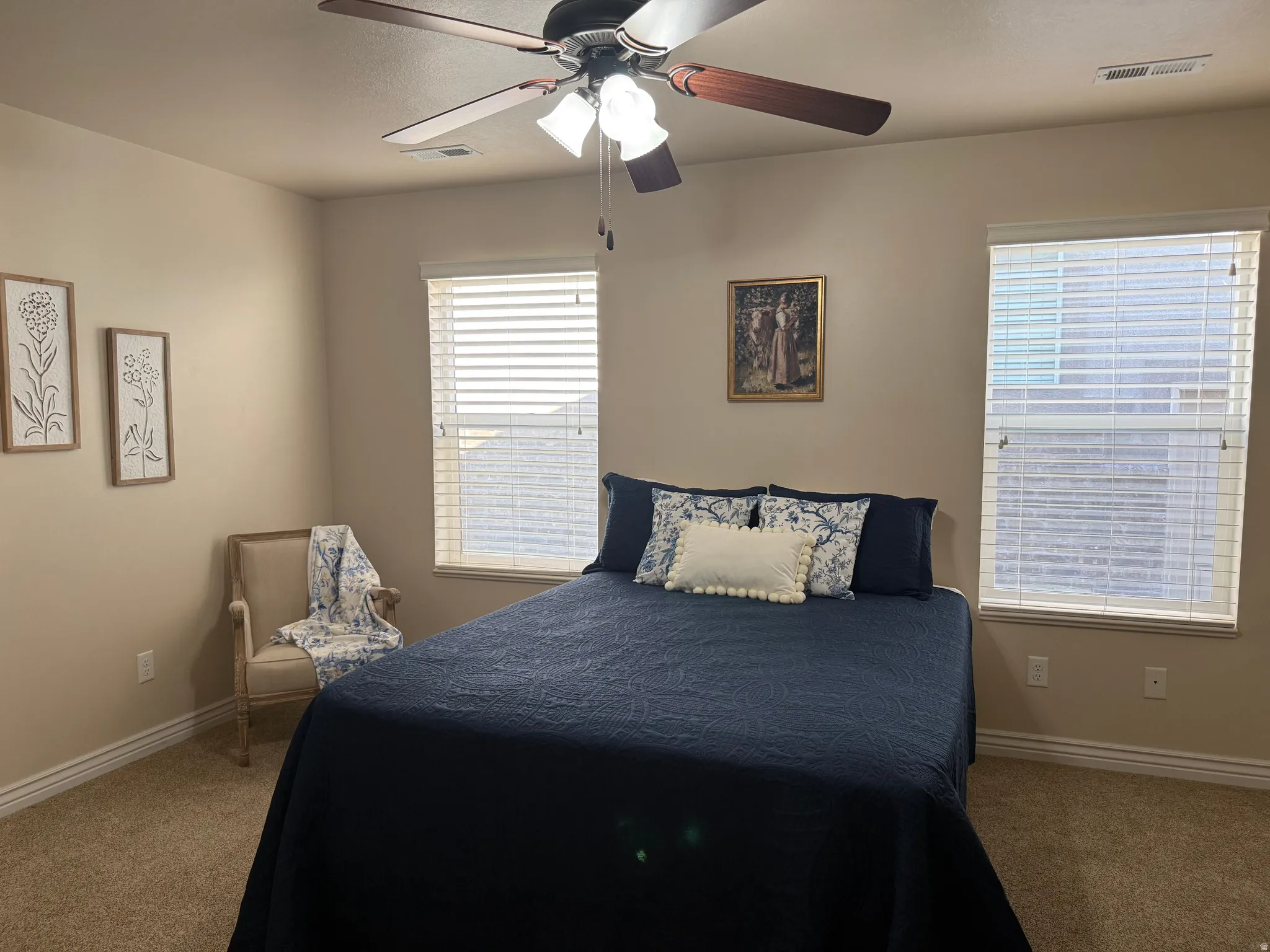 Carpeted room featuring a ceiling fan with integrated lighting, multiple windows with blinds, and neutral painted walls