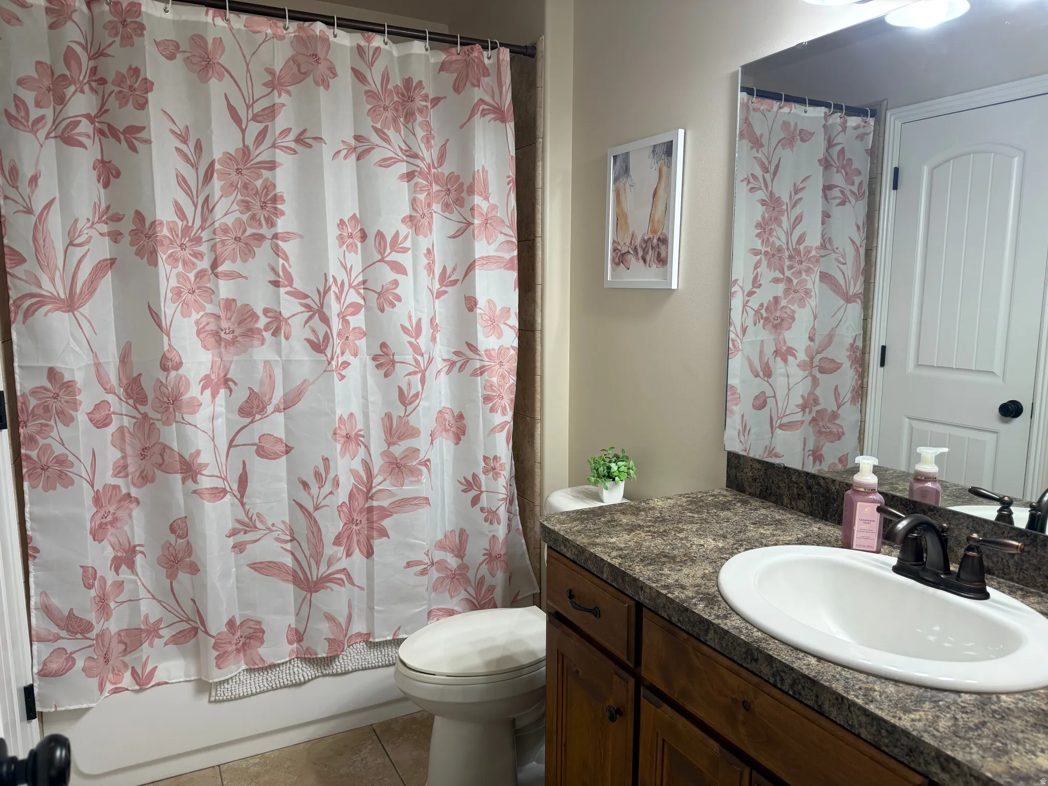 Bathroom featuring a bathtub with tile surround, a built-in vanity with a laminate countertop, an integrated sink, and an oil-rubbed bronze faucet