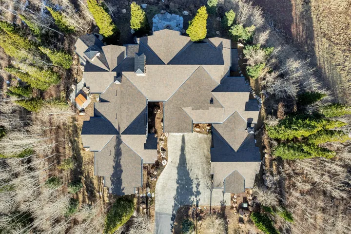 Expansive property featuring a multi-gabled roofline, varied roof elevations, and an elongated driveway