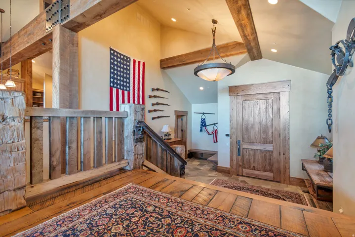 Entryway featuring a solid wood door, vaulted ceilings with exposed wood beams, and recessed lighting