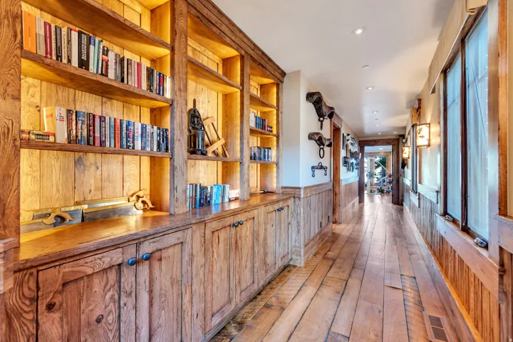 Hallway featuring extensive wood-finish flooring and paneling
