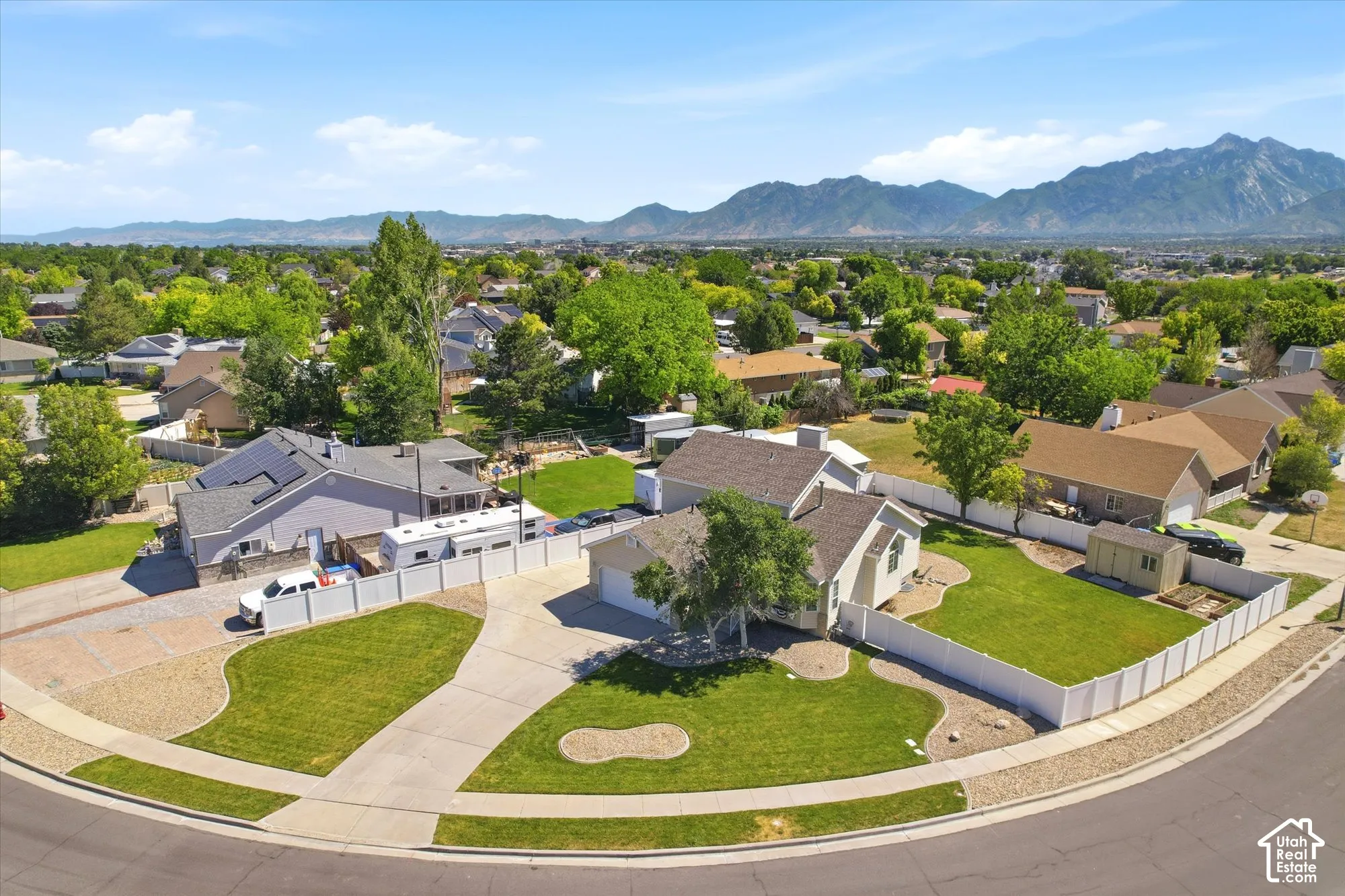 Residential property featuring a spacious cul-de-sac lot, concrete driveway, and white privacy fencing
