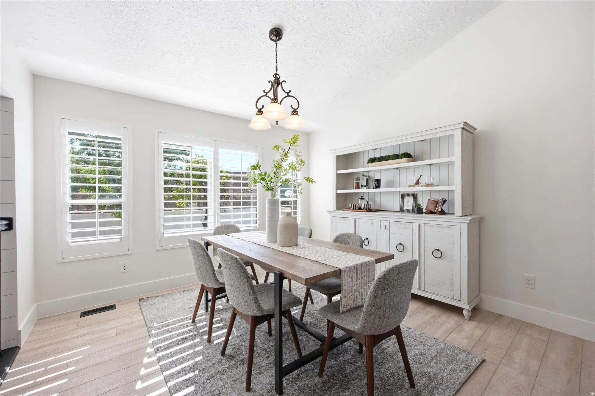 Dining area featuring light wood-finish flooring and a white color palette