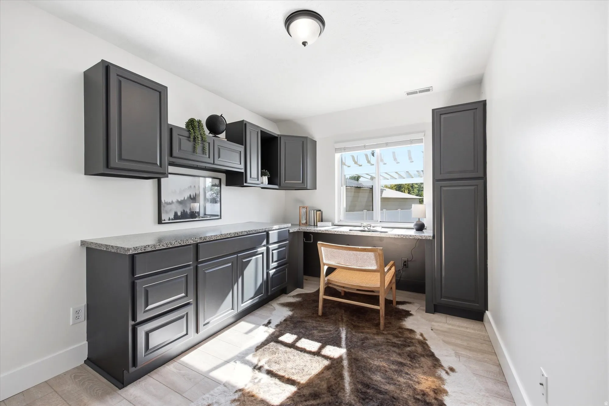Built-in cabinetry in a dark finish provides extensive storage and a dedicated workspace