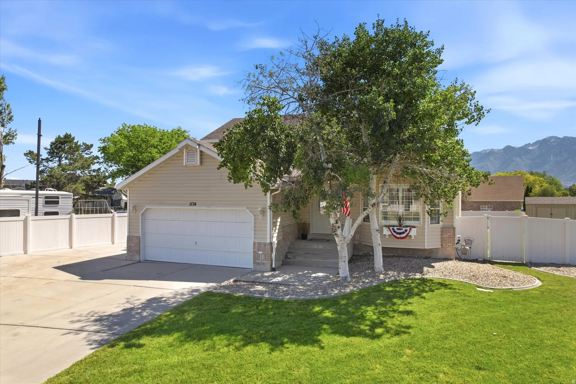 Single-story residence featuring light-colored siding, an attached two-car garage, and a concrete driveway
