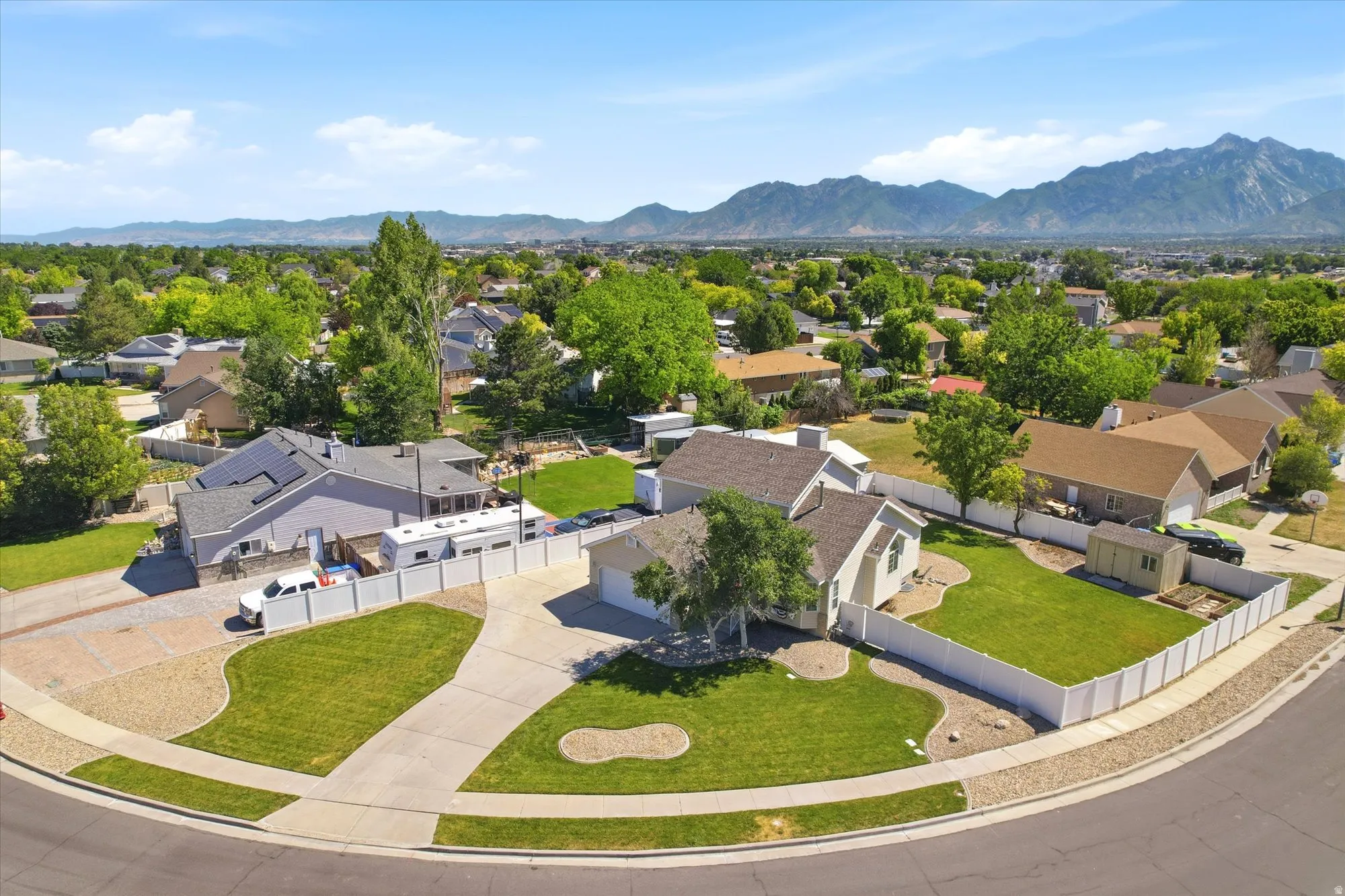 Residential property featuring a spacious cul-de-sac lot, concrete driveway, and white privacy fencing