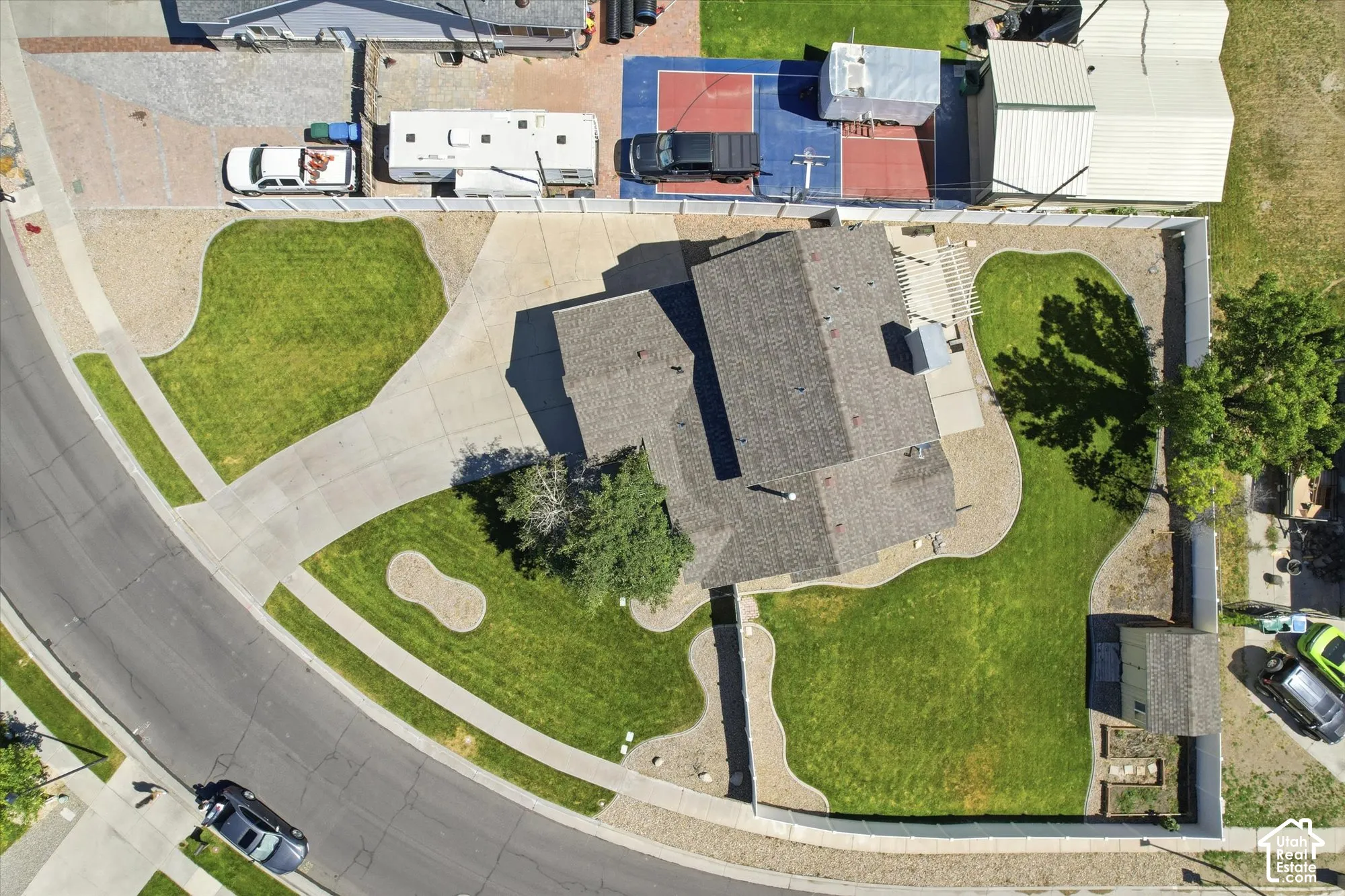 Paved driveway leading to a residence with a shingle roof and a rear pergola