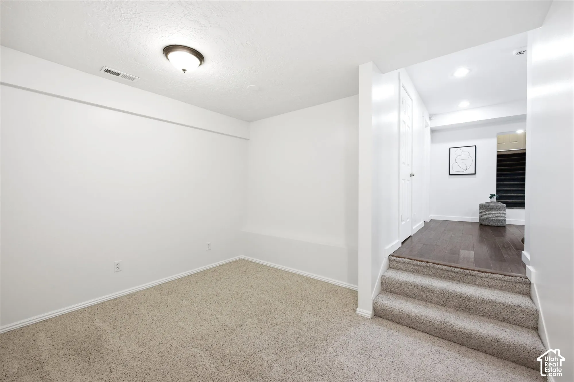 Carpeted room featuring a ceiling-mounted light fixture and baseboard trim