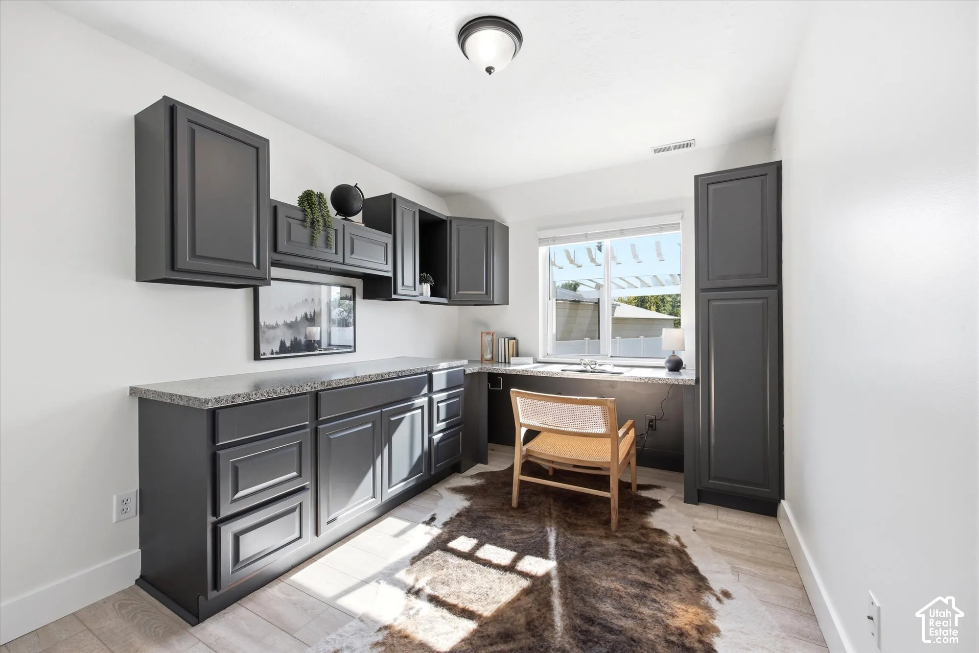 Built-in cabinetry in a dark finish provides extensive storage and a dedicated workspace