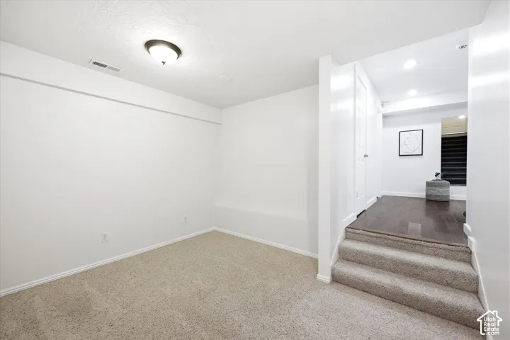 Carpeted room featuring a ceiling-mounted light fixture and baseboard trim