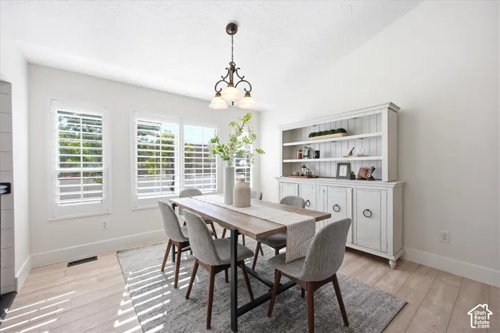 Dining area featuring light wood-finish flooring and a white color palette