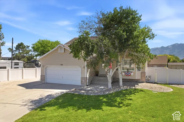 Single-story residence featuring light-colored siding, an attached two-car garage, and a concrete driveway