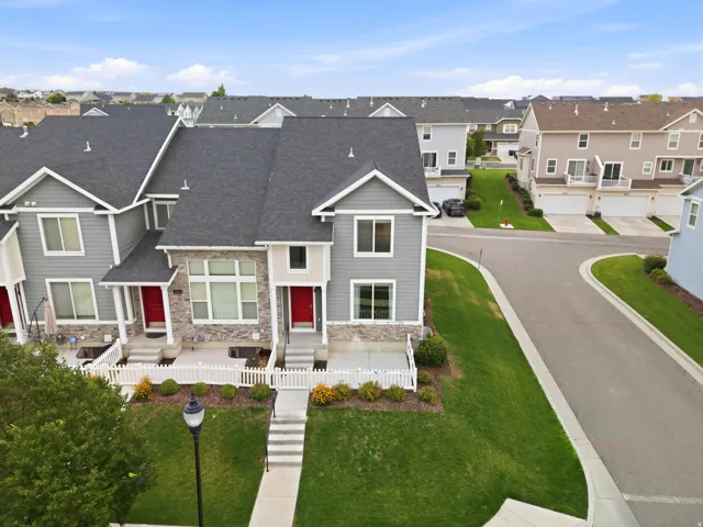 Contemporary townhome featuring gray siding with stone veneer accents