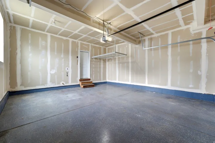 Spacious garage featuring an epoxy-coated concrete floor and built-in overhead storage racks