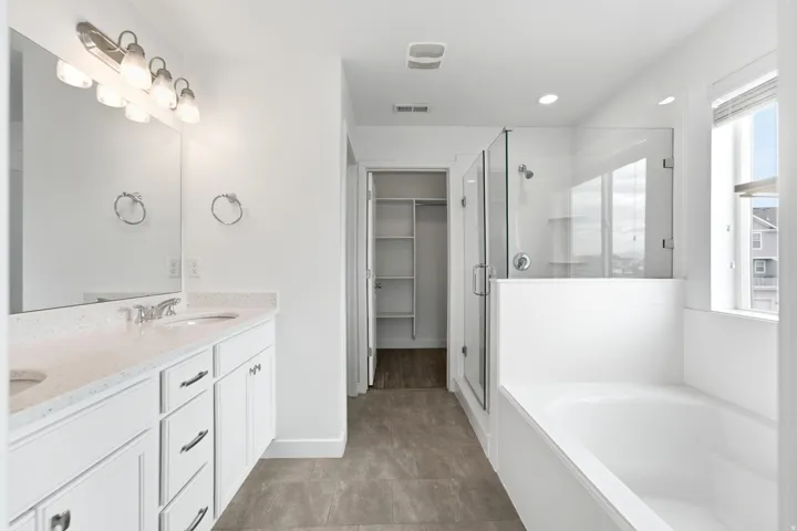 Bathroom featuring dual vanity with quartz countertops, undermount sinks, and chrome fixtures