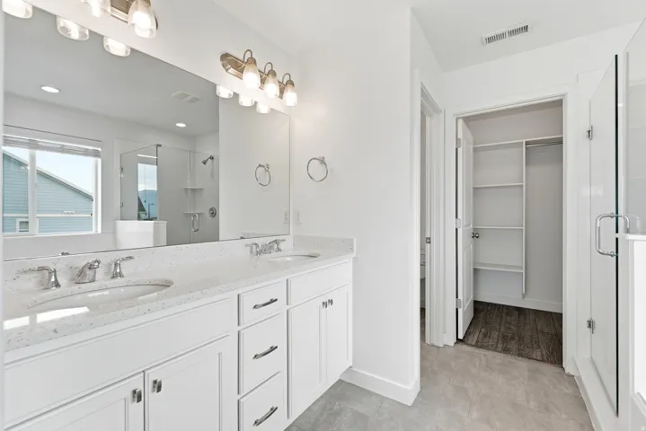 Double vanity with undermount sinks, speckled white countertops, and chrome fixtures