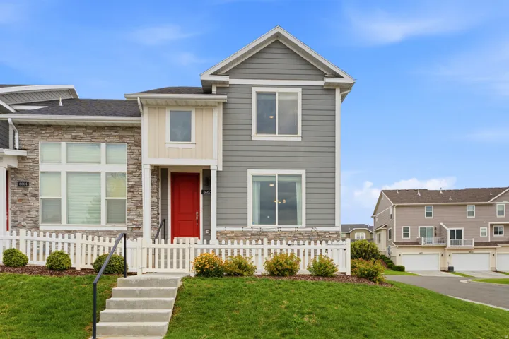 Modern exterior featuring grey siding and stone veneer accents