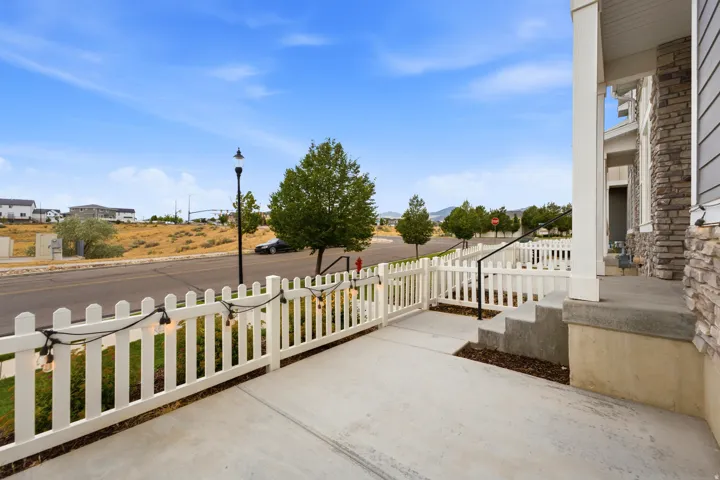 Front porch featuring concrete steps and a white picket fence