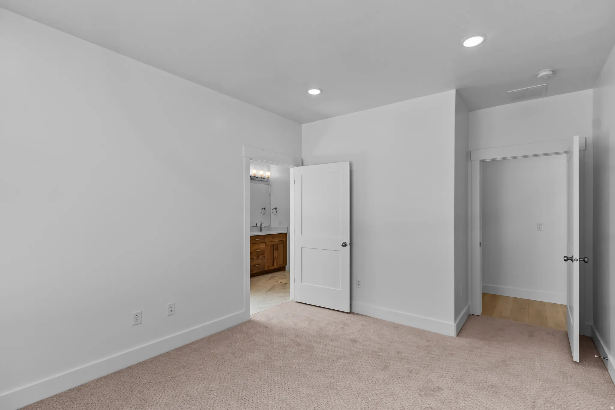 Spacious room featuring neutral carpeting and recessed lighting